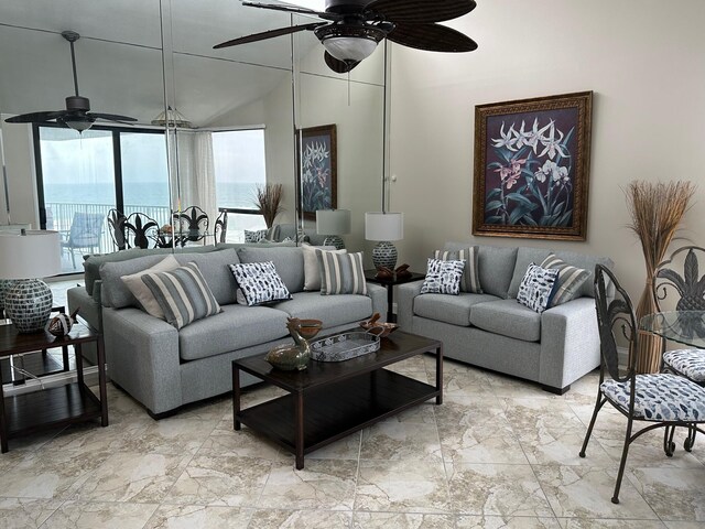 living room with a wealth of natural light, ceiling fan, light tile floors, and a water view