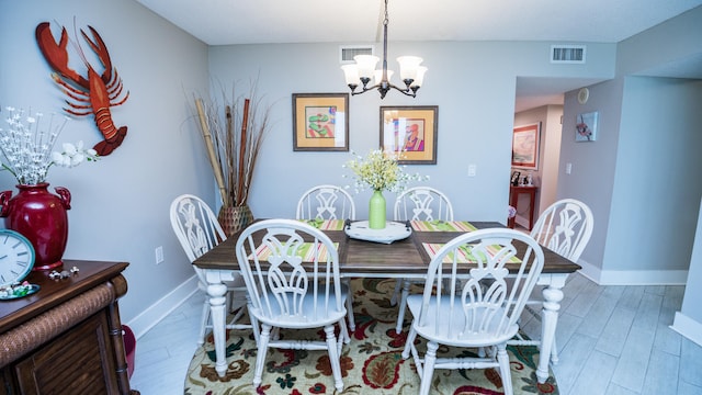 dining area featuring dark hardwood / wood-style flooring and an inviting chandelier