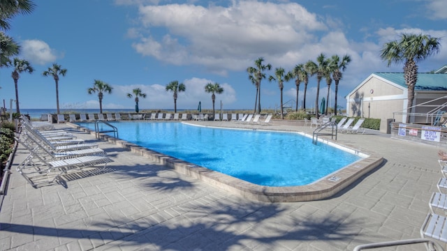 view of pool with a patio area and a water view