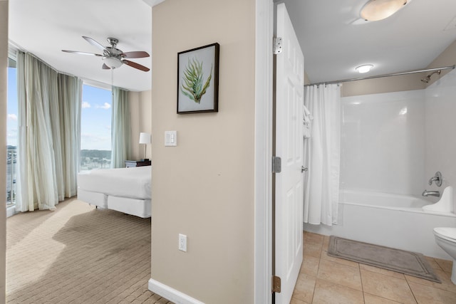 bathroom with toilet, ceiling fan, shower / bath combo with shower curtain, and tile flooring