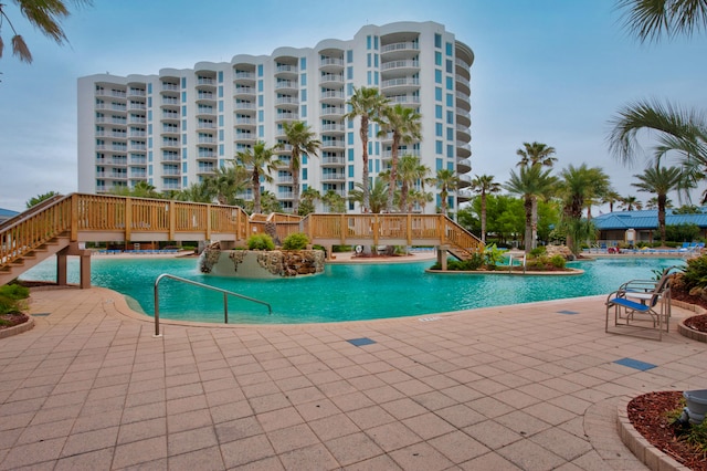 view of swimming pool featuring pool water feature and a patio