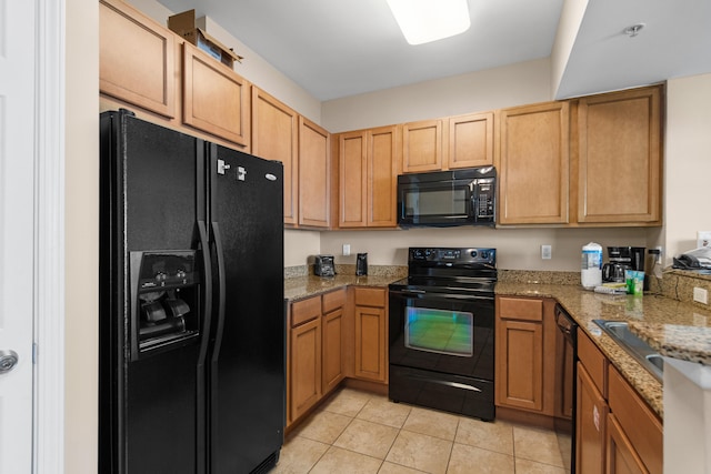 kitchen with light stone counters, light tile floors, and black appliances