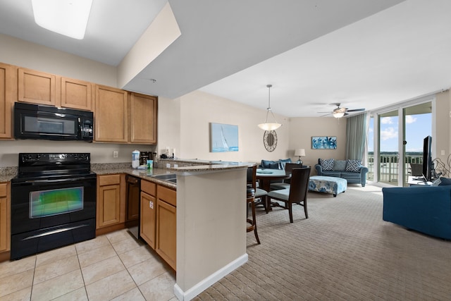 kitchen with ceiling fan, dark stone counters, decorative light fixtures, black appliances, and kitchen peninsula