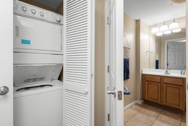 washroom with sink, light tile floors, and stacked washer and dryer