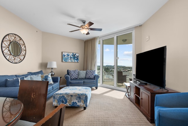 living room with light colored carpet, ceiling fan, and floor to ceiling windows