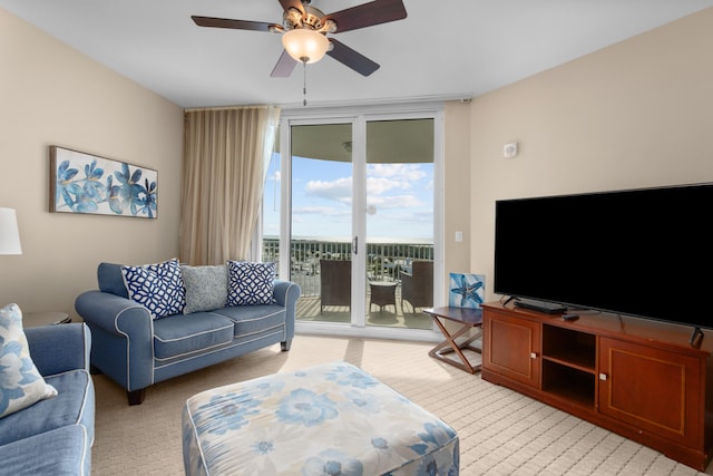 carpeted living room featuring ceiling fan and a wall of windows