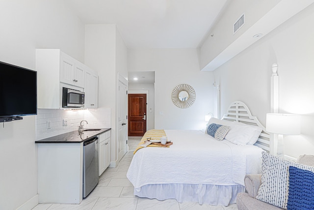 bedroom with a towering ceiling, light tile floors, and sink