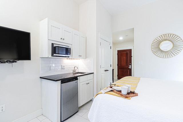 kitchen featuring appliances with stainless steel finishes, tasteful backsplash, white cabinetry, and light tile floors