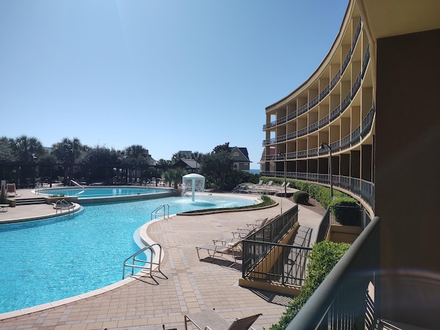 view of pool with pool water feature and a patio area