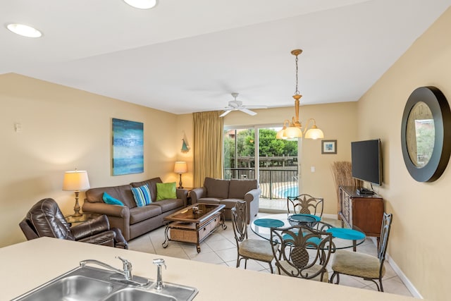 tiled living room with ceiling fan with notable chandelier and sink