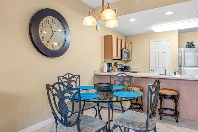 tiled dining room featuring sink