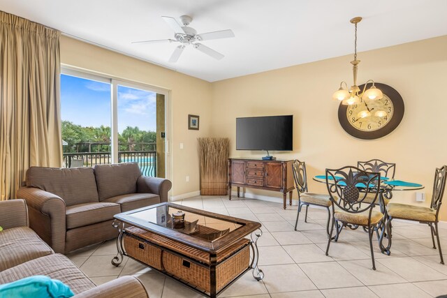 tiled living room featuring ceiling fan with notable chandelier