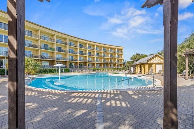 view of swimming pool with a patio and pool water feature