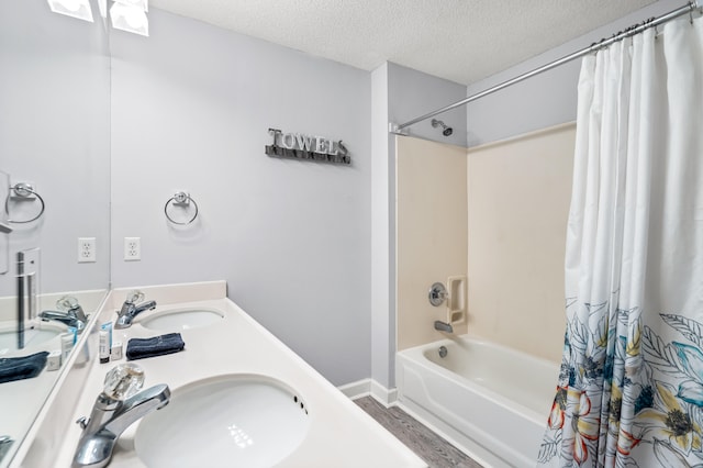 bathroom with wood-type flooring, a textured ceiling, shower / bath combination with curtain, and double vanity