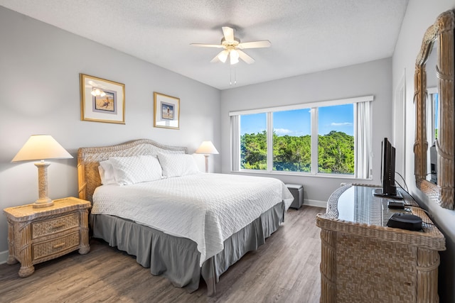 bedroom featuring dark wood-type flooring, ceiling fan, and a textured ceiling