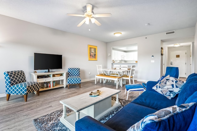 living room featuring ceiling fan and light wood-type flooring