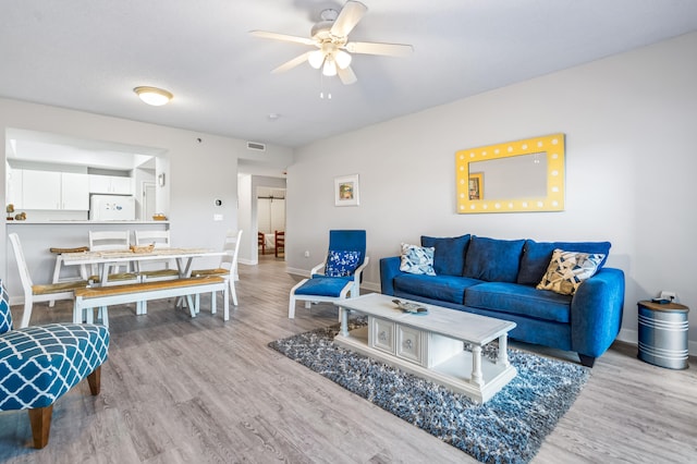 living room with ceiling fan and light hardwood / wood-style floors