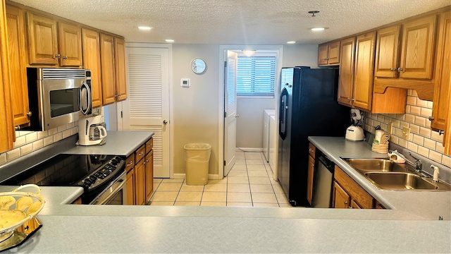 kitchen with tasteful backsplash, appliances with stainless steel finishes, a textured ceiling, and sink