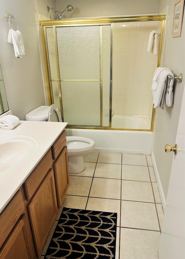 full bathroom featuring vanity, tile floors, toilet, and combined bath / shower with glass door