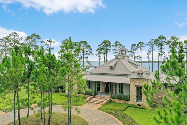 view of front of home with a water view, a front lawn, and covered porch