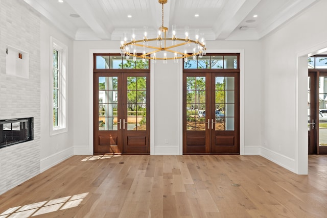 entryway featuring plenty of natural light, french doors, light hardwood / wood-style floors, and an inviting chandelier