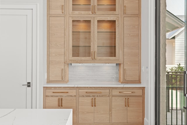 bar featuring light brown cabinetry and plenty of natural light