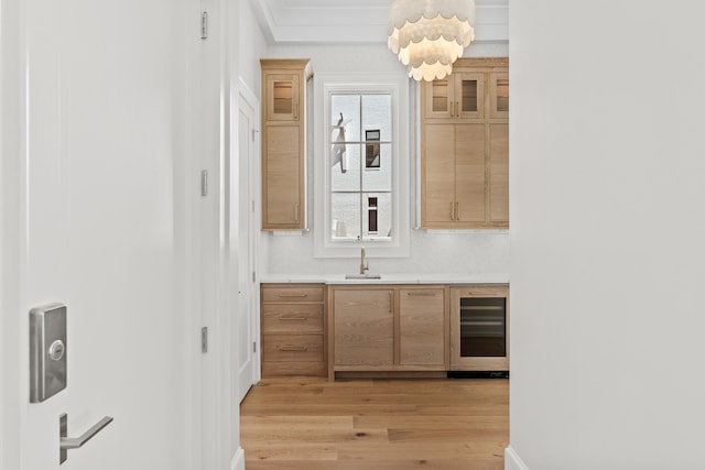 kitchen featuring wine cooler, sink, and light wood-type flooring