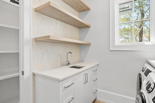 laundry area featuring sink and separate washer and dryer