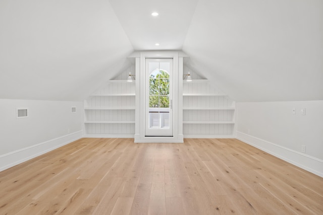 additional living space featuring lofted ceiling and light hardwood / wood-style floors