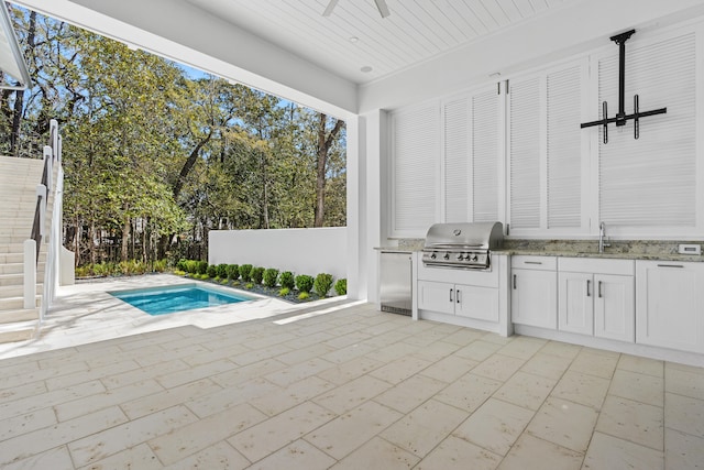 exterior space with a patio area, exterior kitchen, sink, and grilling area