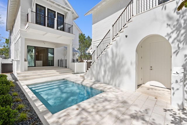 rear view of property with a balcony and a patio area