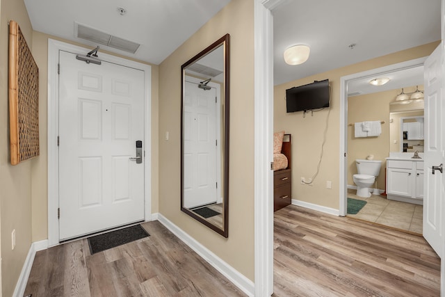 entryway featuring sink and light hardwood / wood-style floors