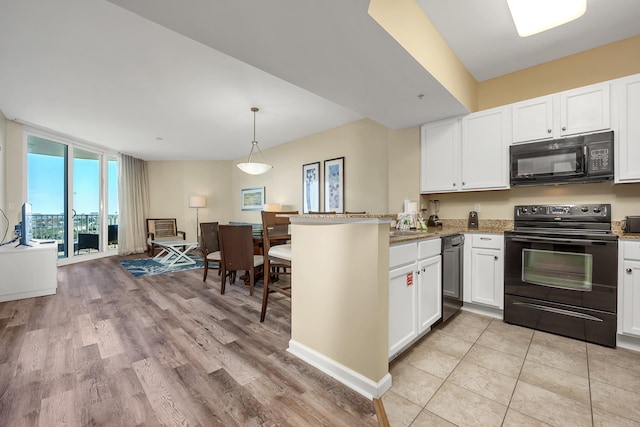 kitchen featuring white cabinetry, kitchen peninsula, pendant lighting, and black appliances