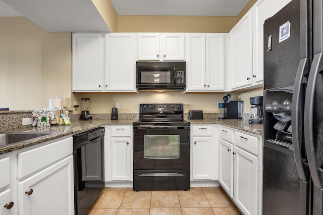 kitchen with stone counters, light tile floors, black appliances, and white cabinetry