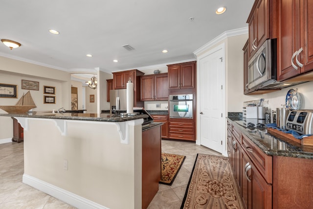 kitchen with an inviting chandelier, appliances with stainless steel finishes, a center island with sink, light tile floors, and a kitchen bar