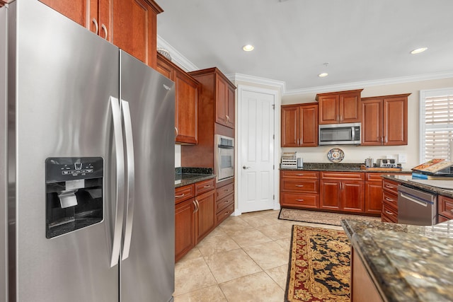 kitchen featuring dark stone countertops, appliances with stainless steel finishes, light tile flooring, and ornamental molding