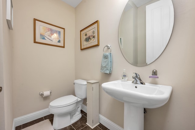 bathroom with toilet and tile floors