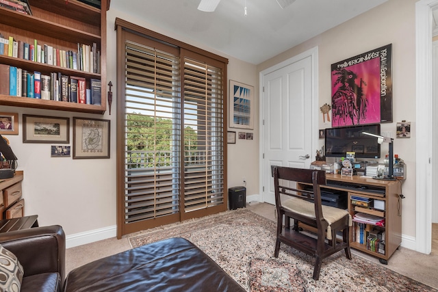 carpeted office space featuring ceiling fan