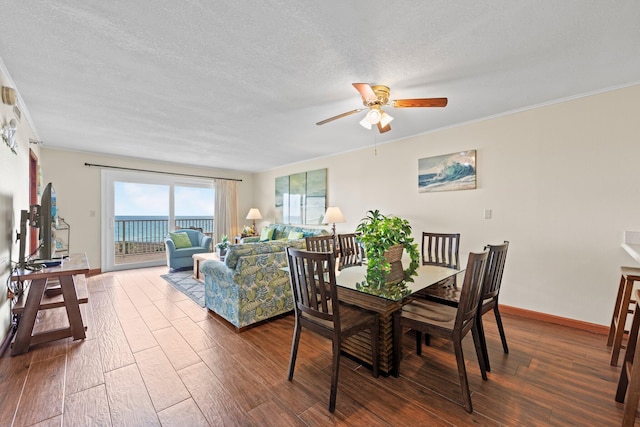 dining room featuring ceiling fan, dark hardwood / wood-style flooring, a textured ceiling, and ornamental molding