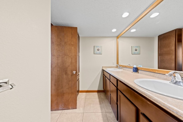 bathroom with tile flooring, dual bowl vanity, and a textured ceiling