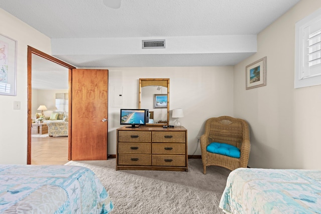 bedroom featuring light colored carpet and a textured ceiling