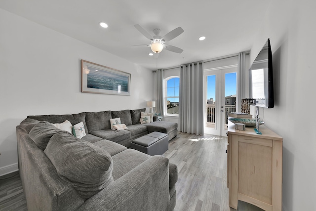 living room with french doors, ceiling fan, and light wood-type flooring