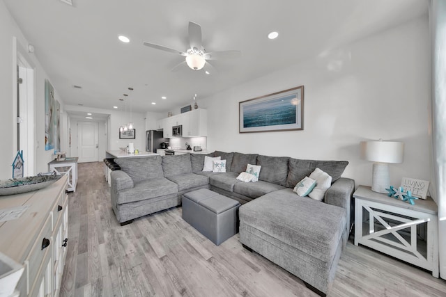 living room featuring ceiling fan and light wood-type flooring