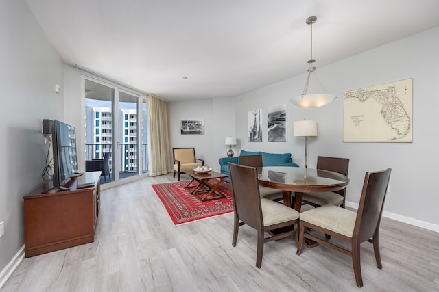 dining area featuring floor to ceiling windows and light hardwood / wood-style flooring