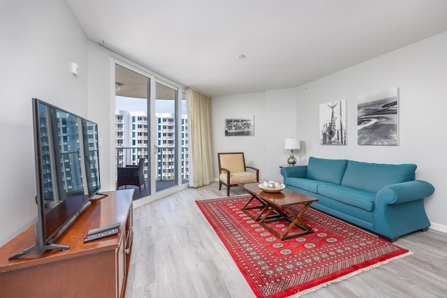 living room with light hardwood / wood-style flooring and a wall of windows