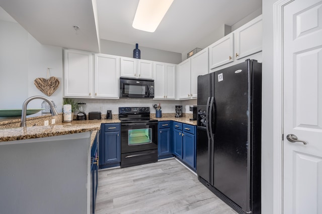 kitchen featuring light stone counters, blue cabinets, kitchen peninsula, white cabinets, and black appliances