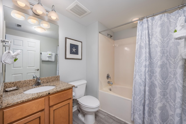 full bathroom featuring shower / bath combo with shower curtain, hardwood / wood-style floors, vanity, and toilet