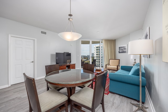 dining room featuring light hardwood / wood-style floors and a wall of windows