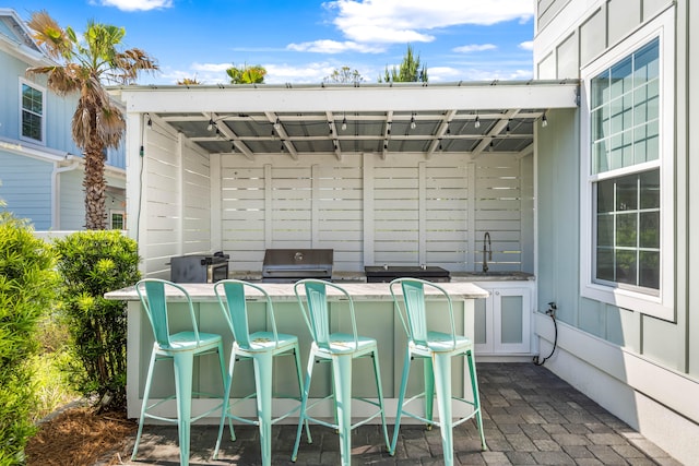 view of terrace featuring area for grilling and a bar