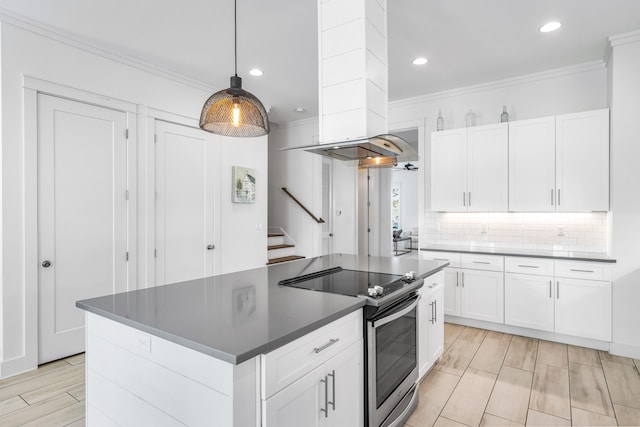 kitchen featuring exhaust hood, electric stove, white cabinets, tasteful backsplash, and ornamental molding